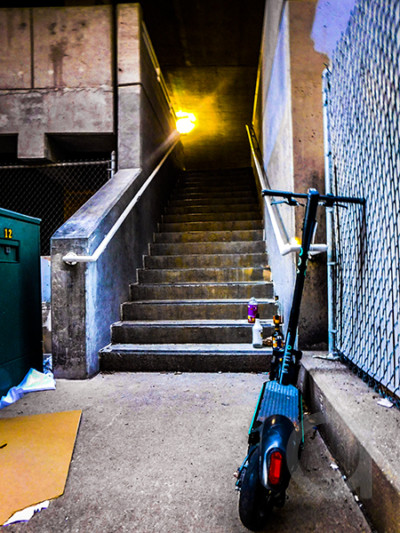 A Scooter Leaning Against a Fence